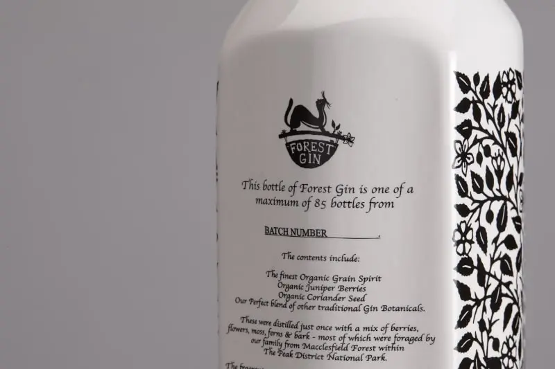 A white ceramic bottle of Forest Gin displaying the ingredients list on the back.