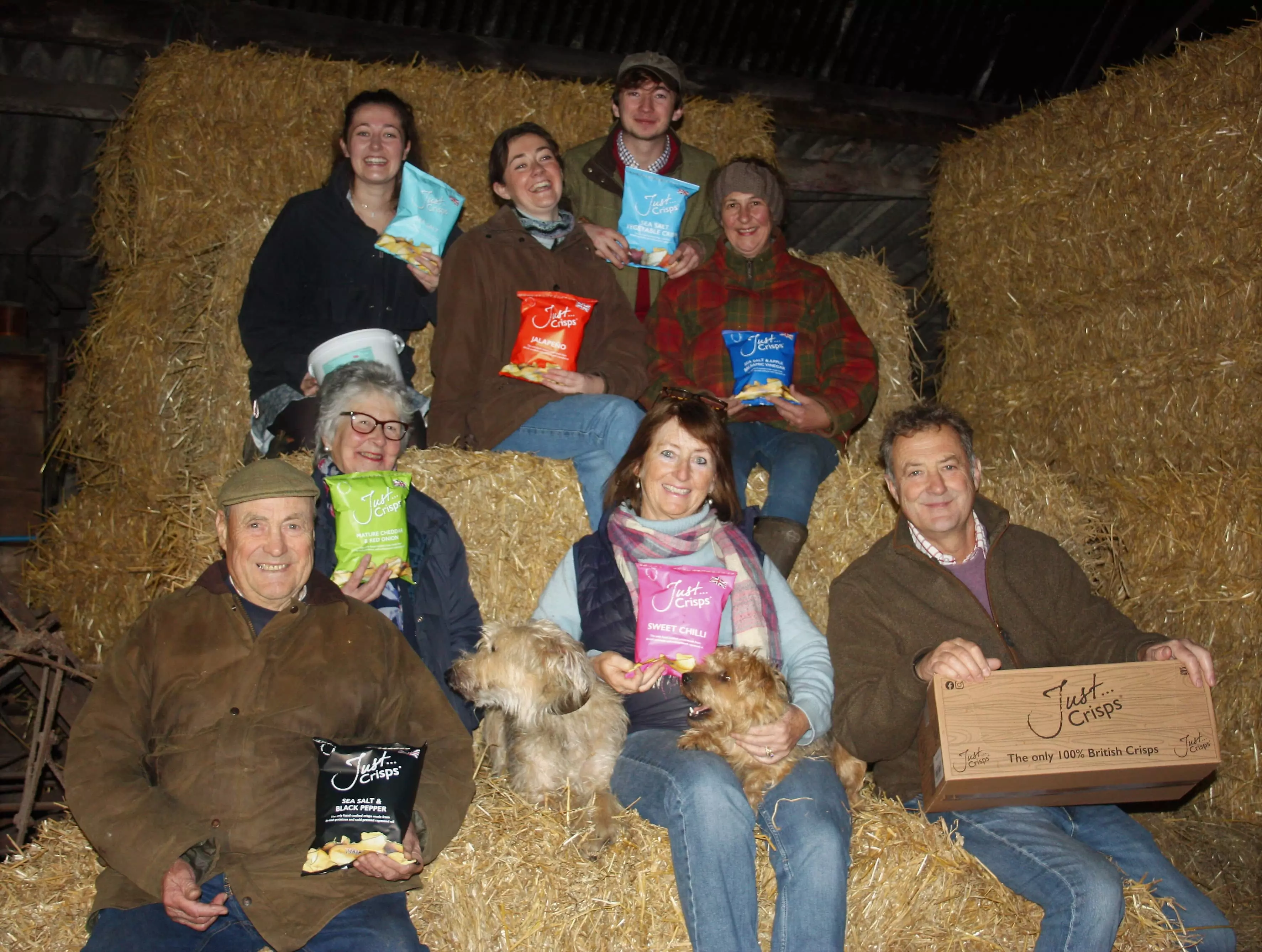 Froggat Family of 8 sat on hay with the crisps they produce