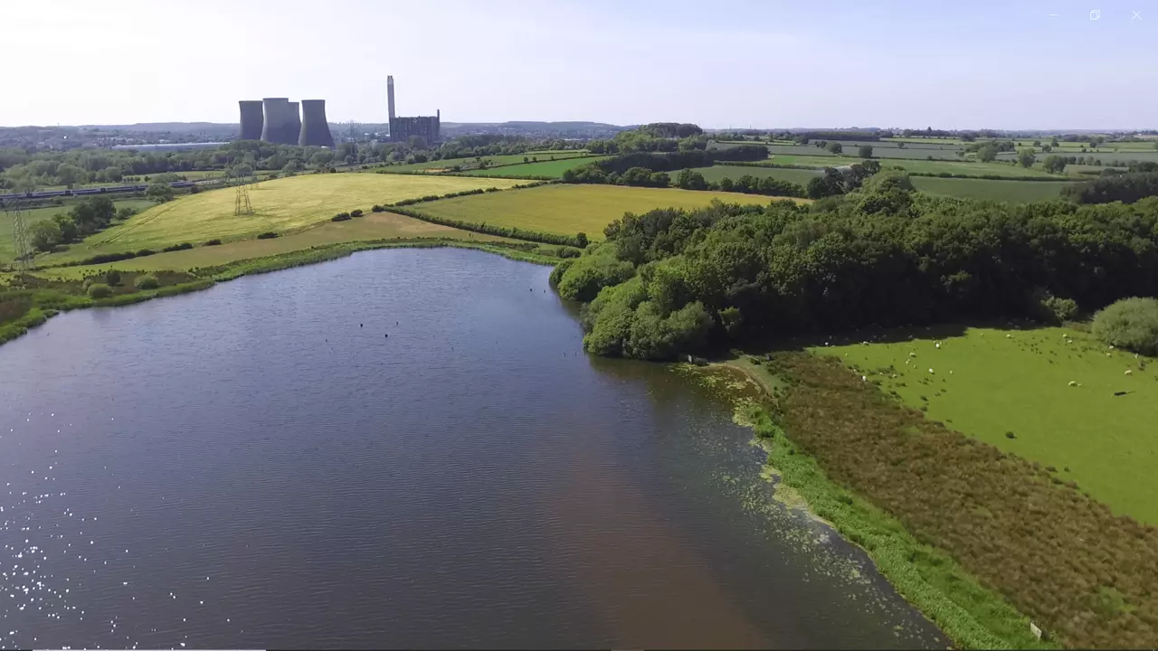 Wade Lane Farm Home Of Just Crisps, a lake with green farmland around it 