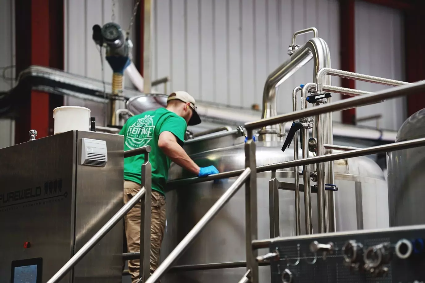 Man looking into a metal barrel of ale