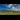 Panorama image of Castlerigg Stone Circle with a blue sky and scattered white clouds