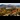 View of Derwent water lake from a hillside showing the trees in autumnal colours and fells in the distance.