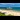 A longshot of Bournemouth beach and pier, featuring people sunbathing on the sand.