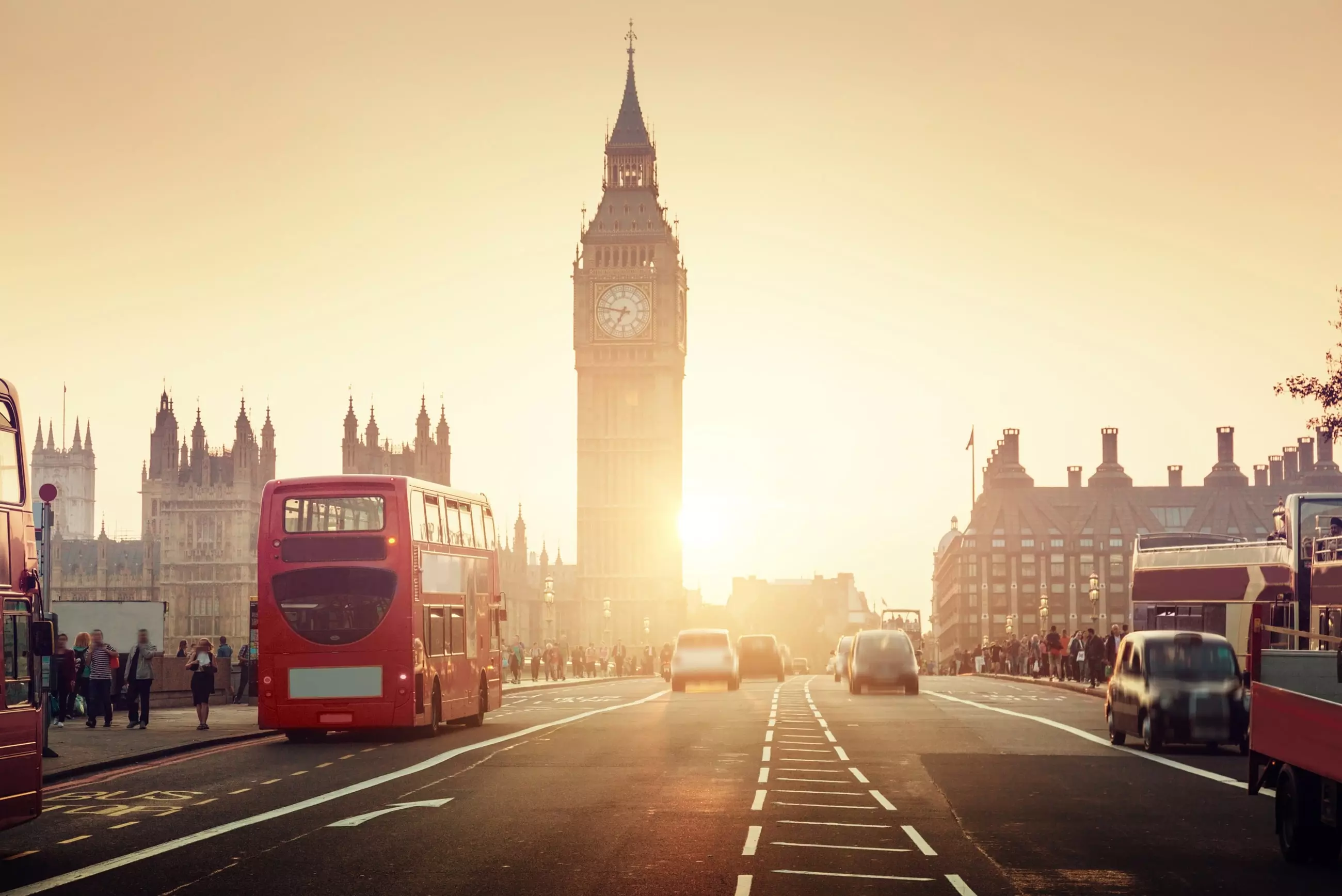 Sepia tone photo showing traffic travelling along a busy London road with Big Ben in the background.