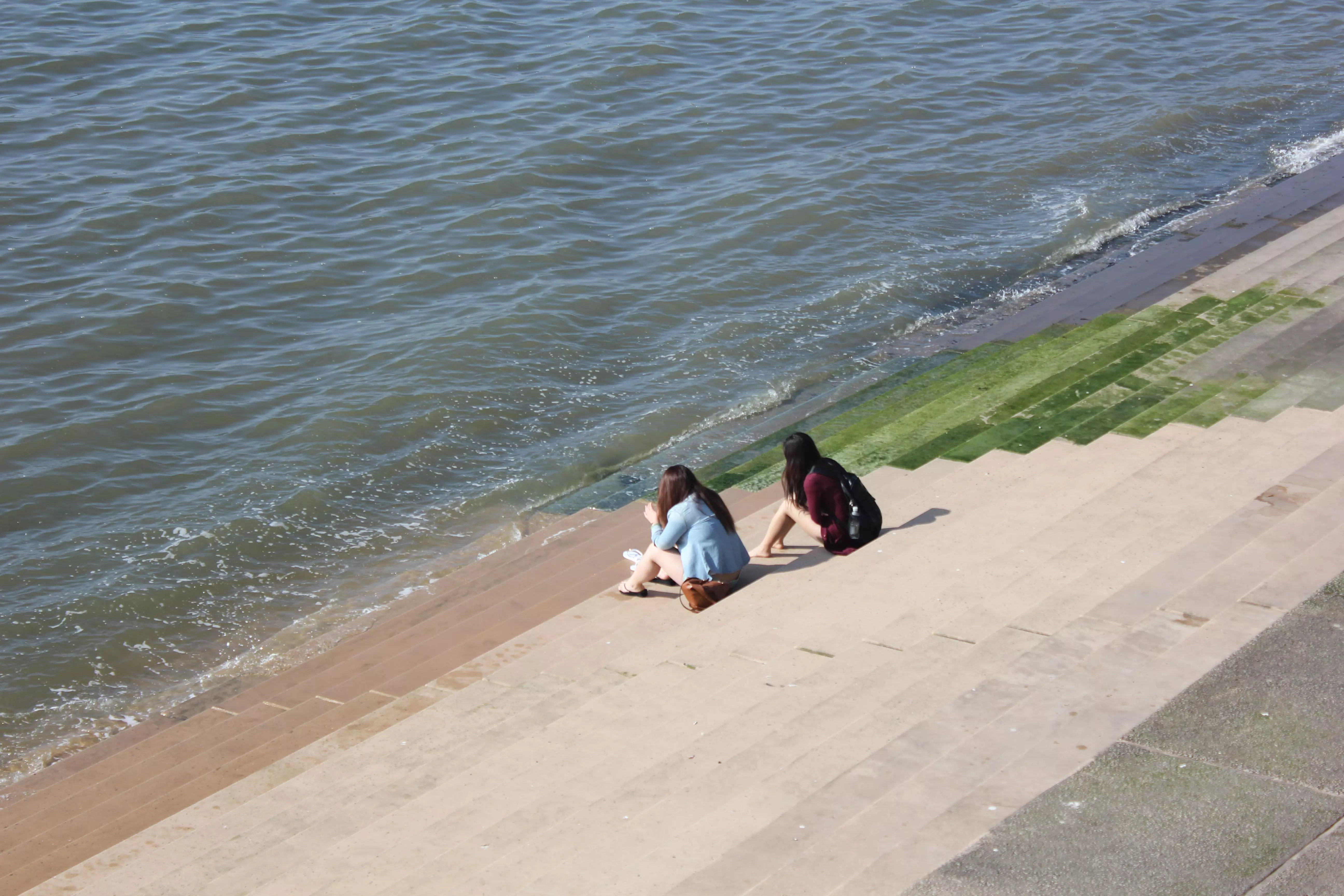 Two girls sitting on Blackpool seafront