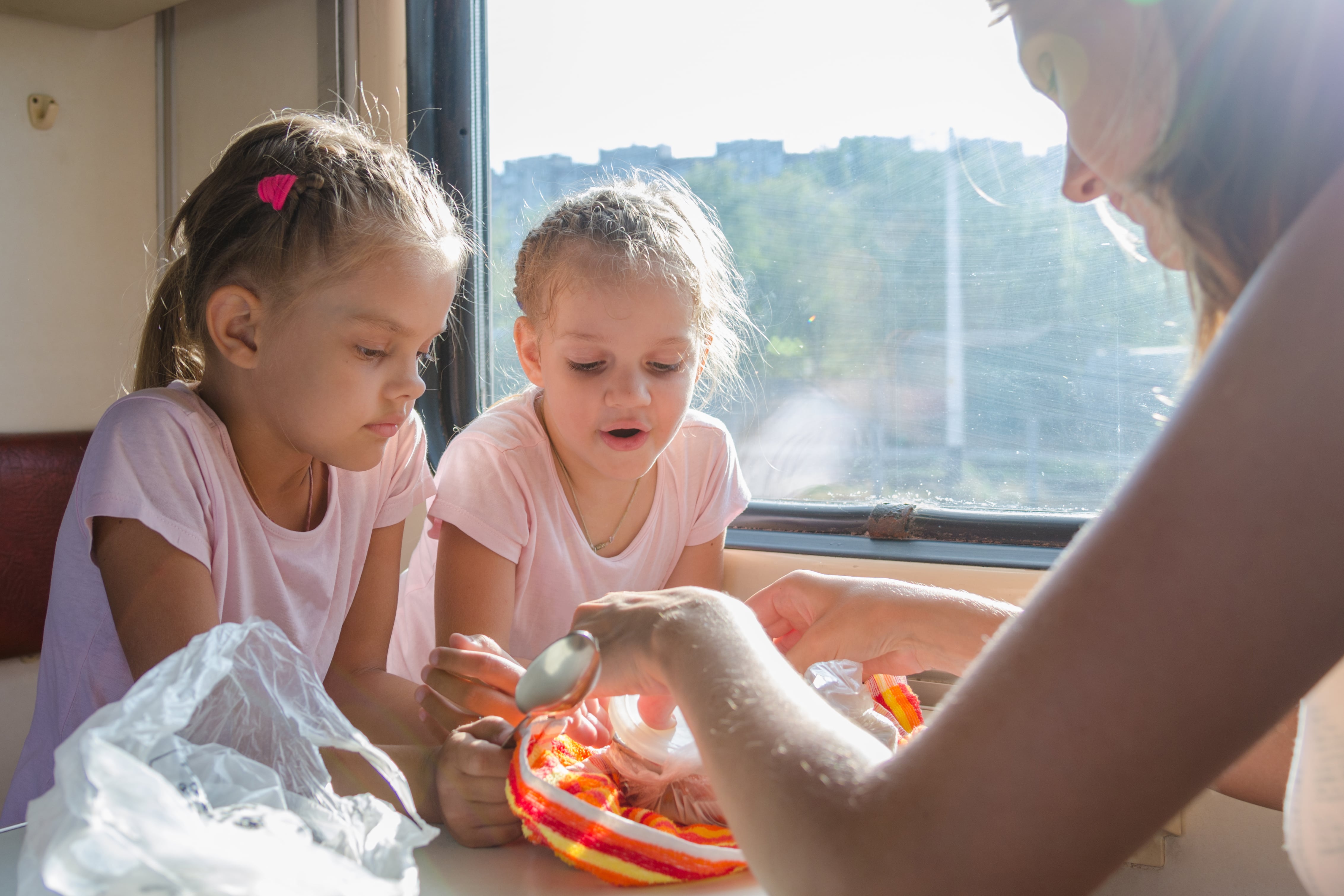 Food on Trains: A mother unpacks food for her two children while sat at the window seat of a train