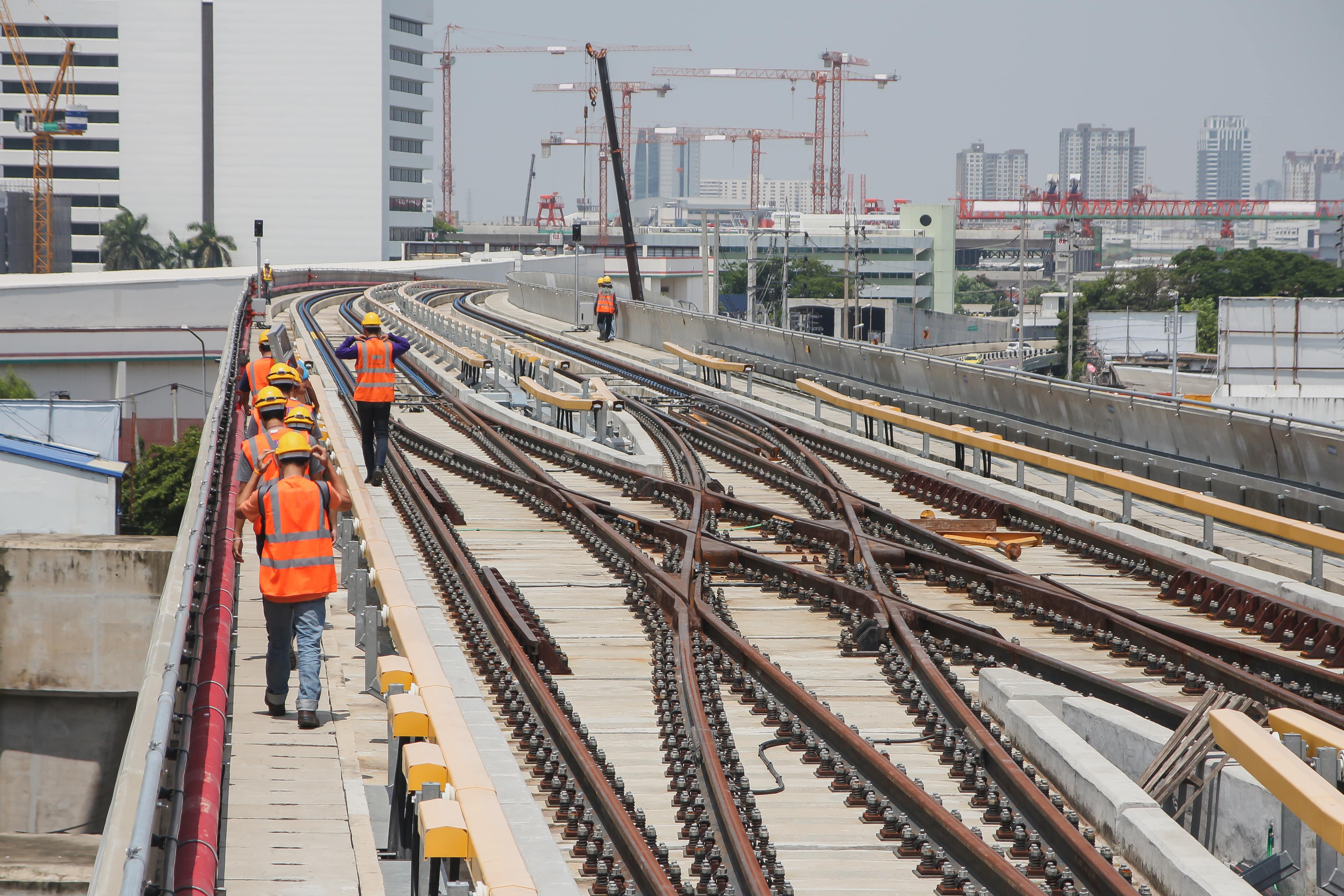 Rail Industrial Relations: A group of railway workers work along an elevated railway line.