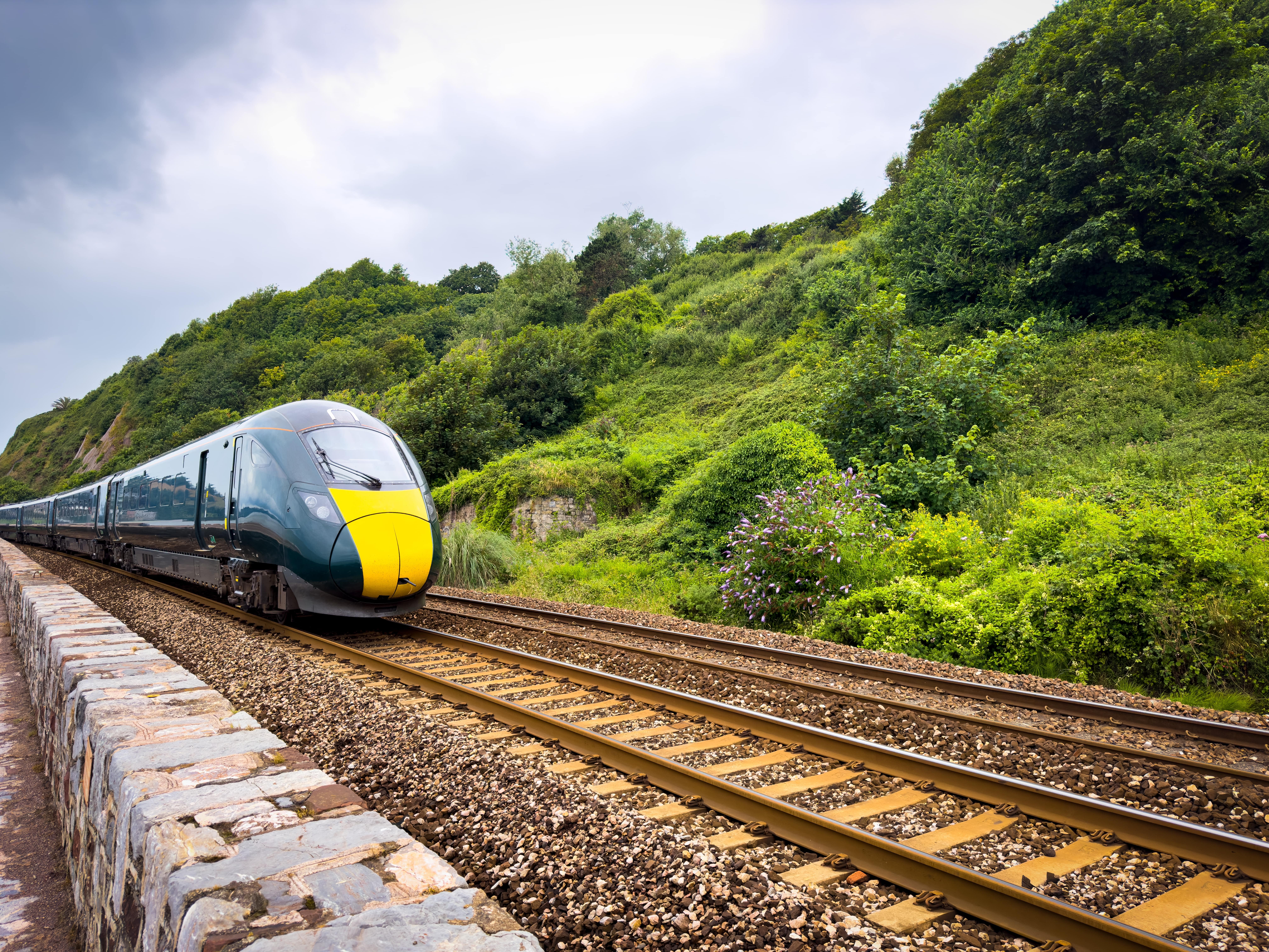Rail Advertising: A modern high-speed train with a sleek black and yellow design travelling along railway tracks