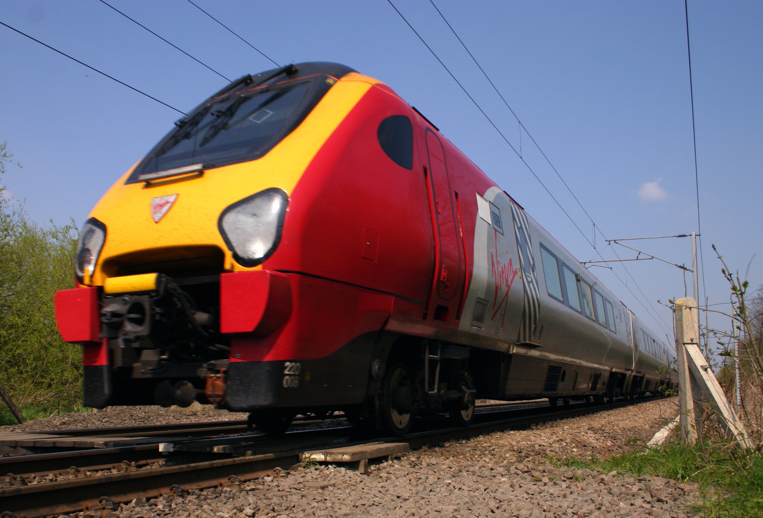 Avanti Trains: A low-angle photo of a Virgin Train moving across the tracks during the day