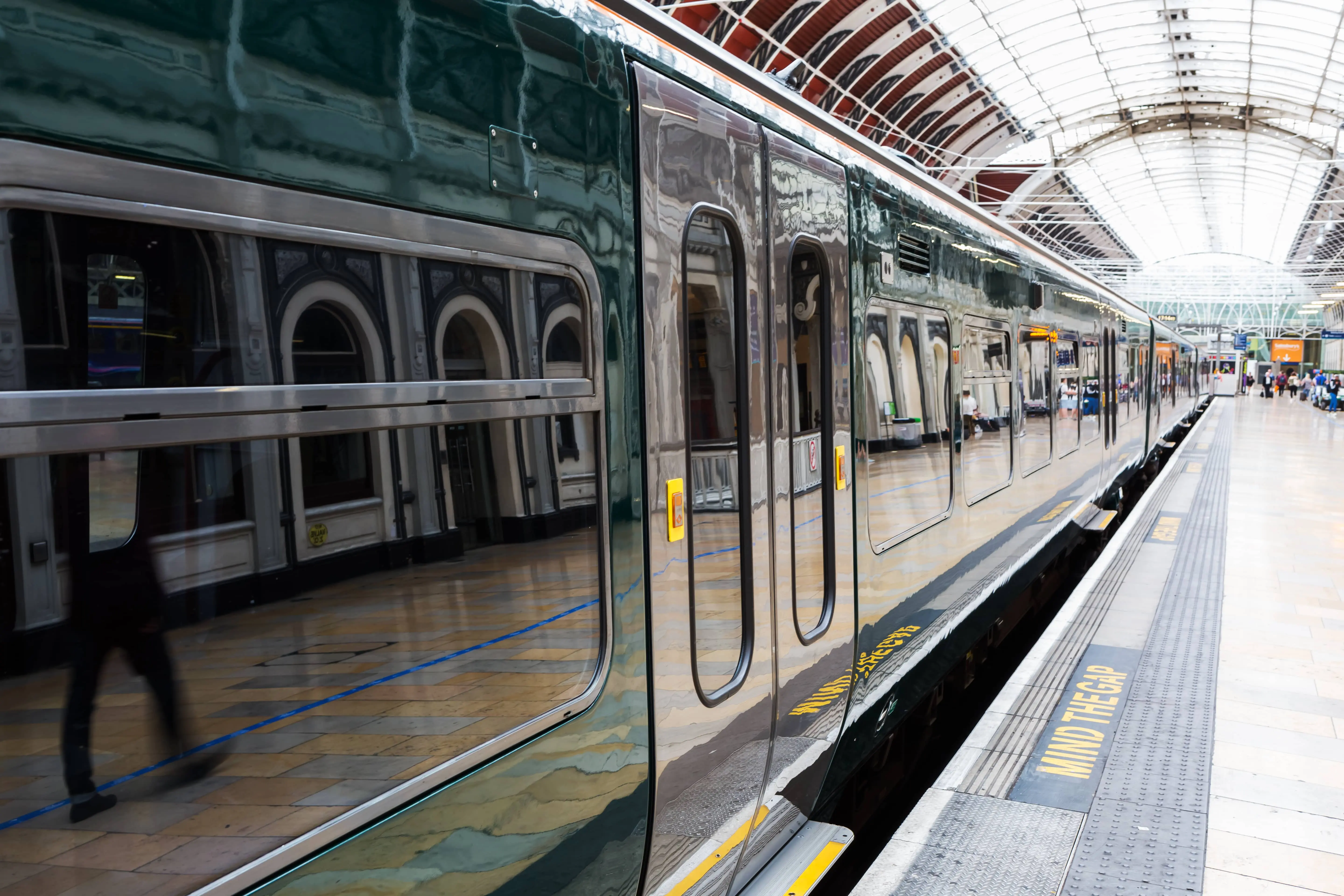 A train stationary at a platform at Paddington Station.