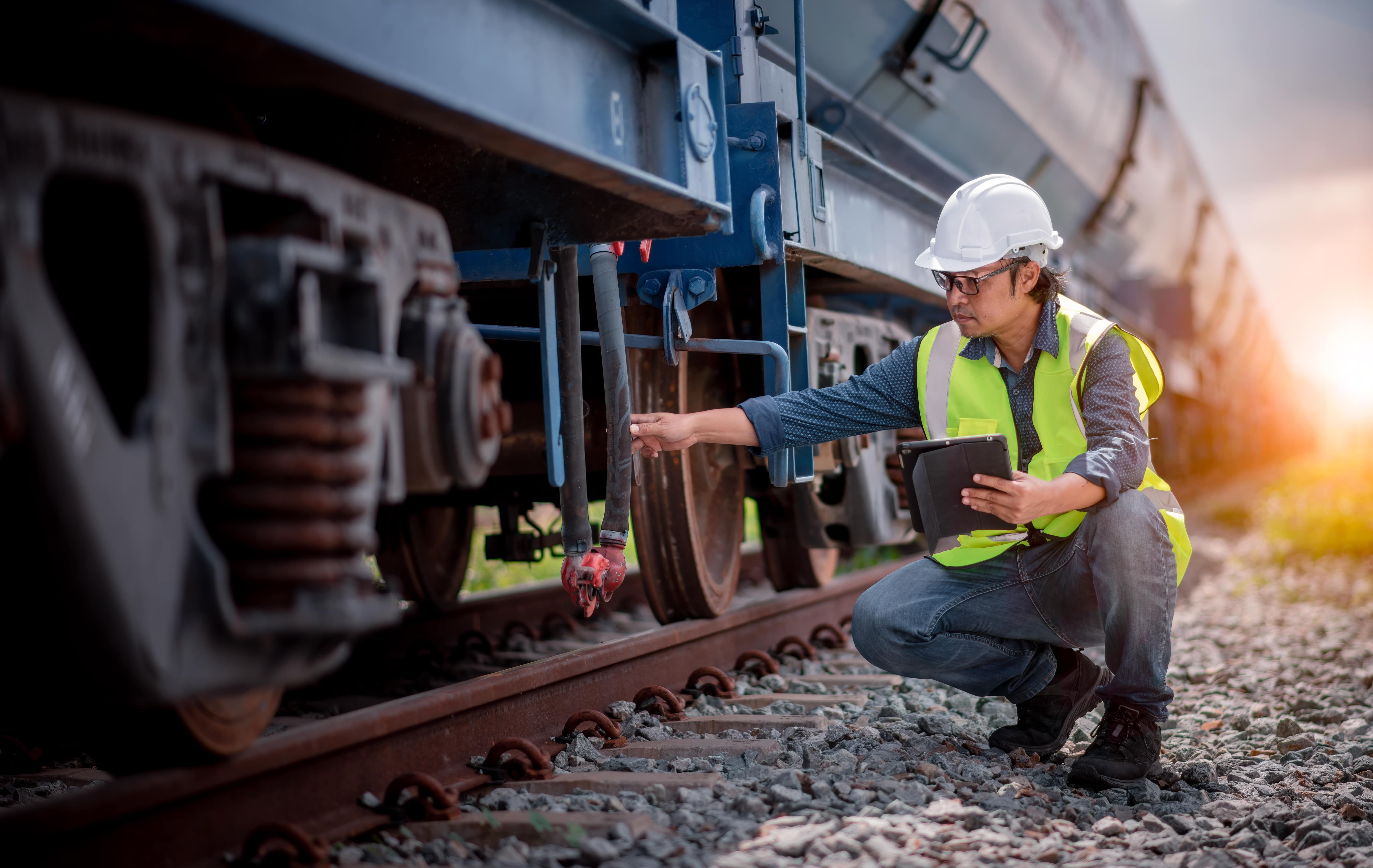 Rail Safety: A railway engineer checks the undercarriage of a train.