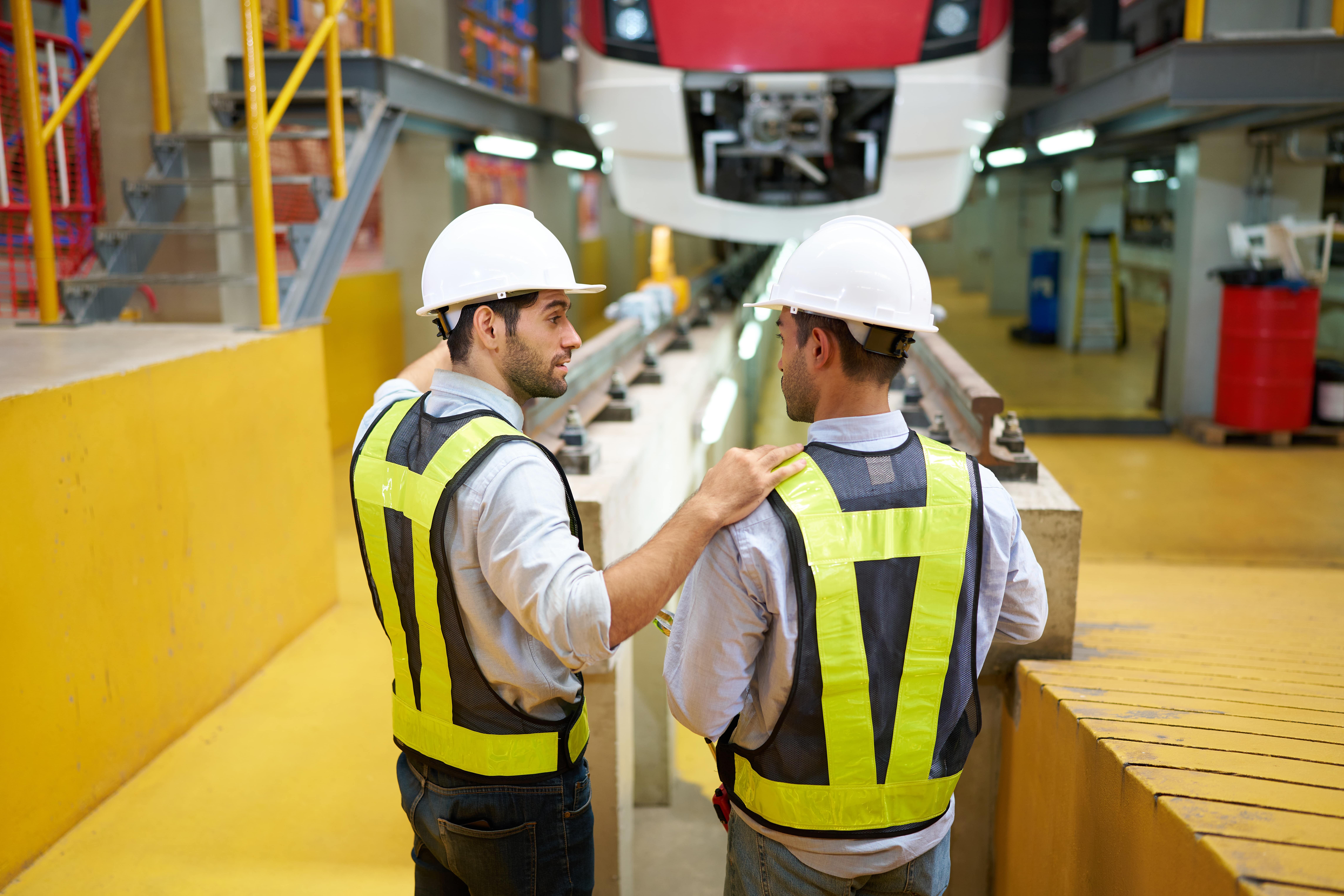 Jobs in Rail: Two train engineers inspecting a train at a maintenance station
