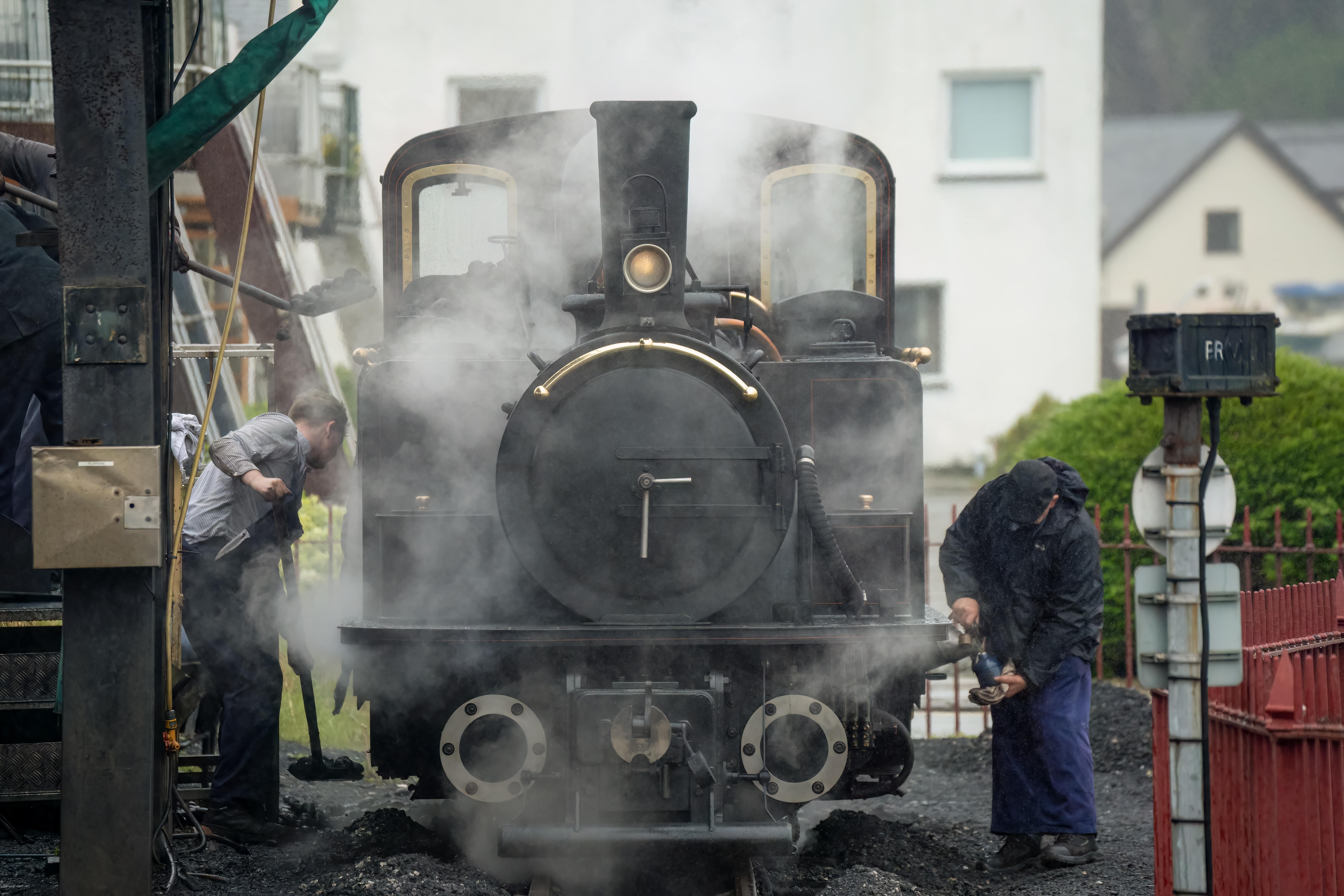 Bicentennial: Steam locomotive undergoing maintenance, with workers tending to the engine as steam rises around them