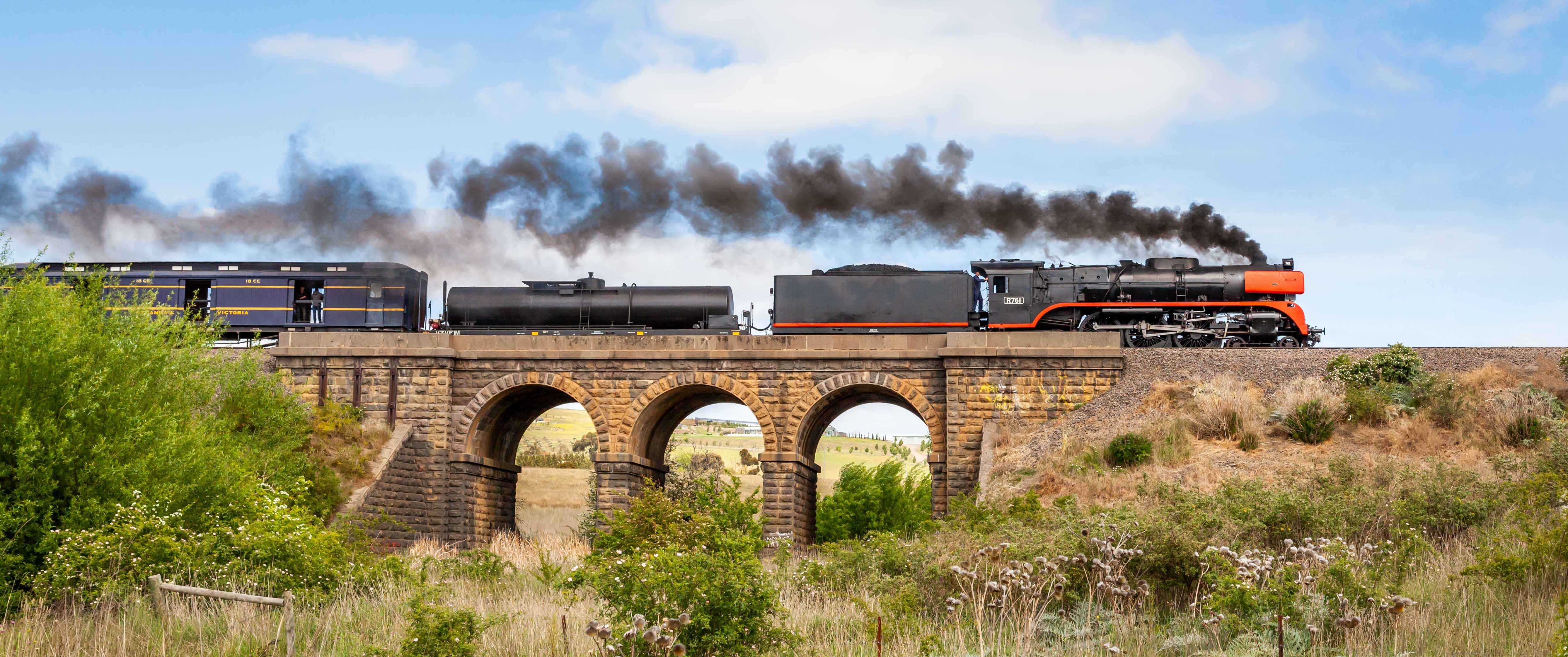 Train Spotting: A steam engine train travelling over a stone bridge