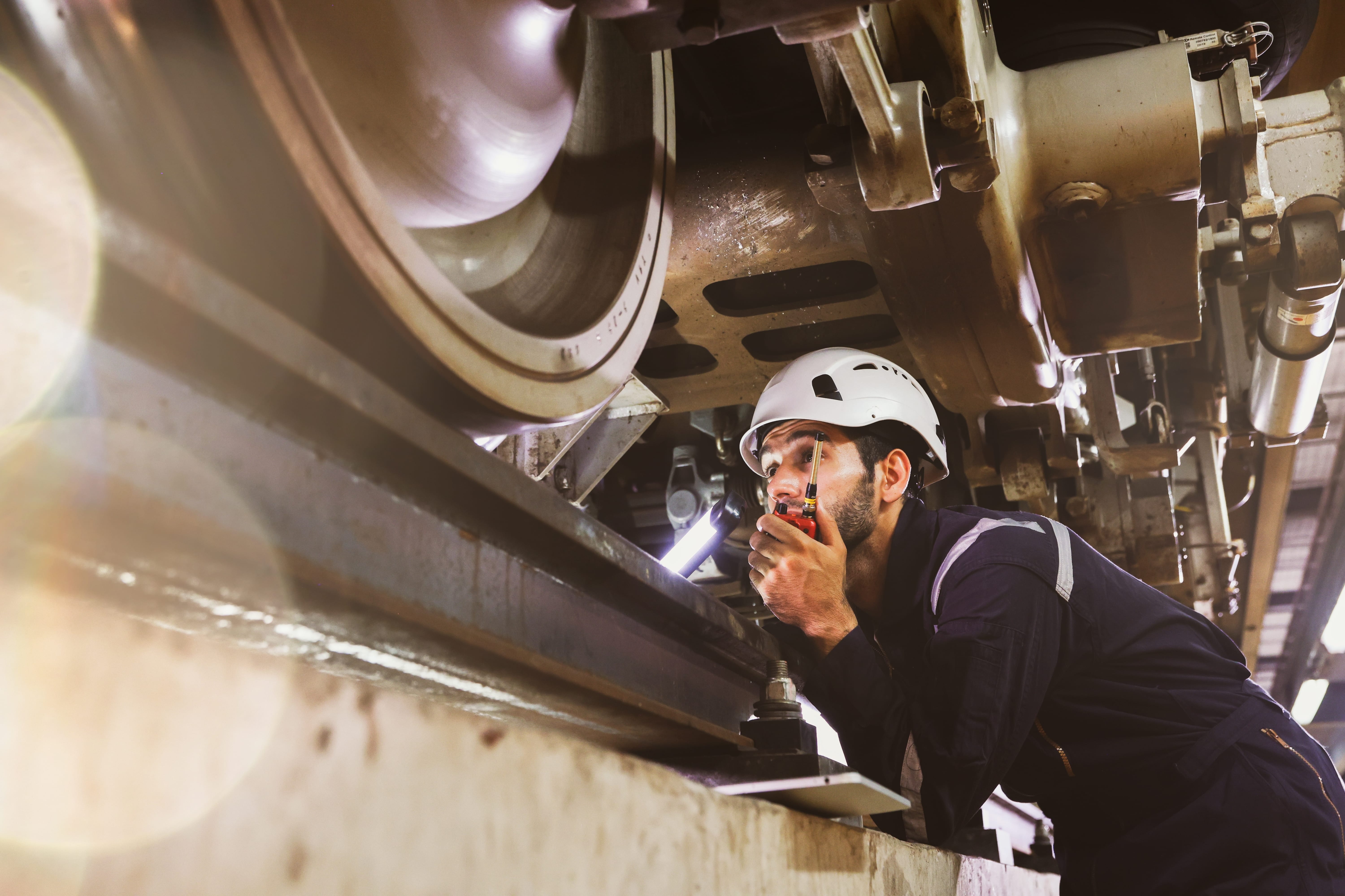 Future Trains: An engineer peers under a stationary train as they contemplate it
