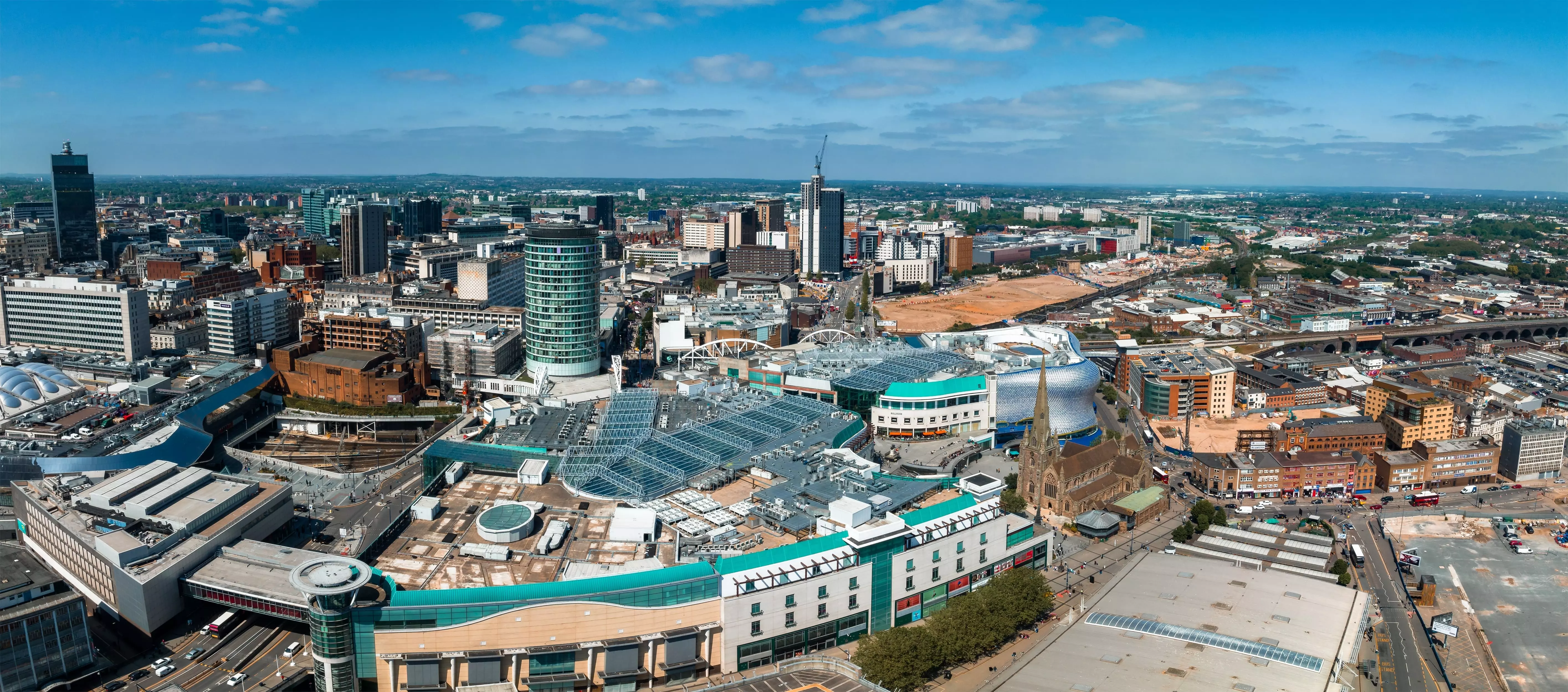 A view of Birmingham’s skyline from above on a bright day with clear skies. Locations visible in the picture include St Martin and the Bullring shopping centre.
