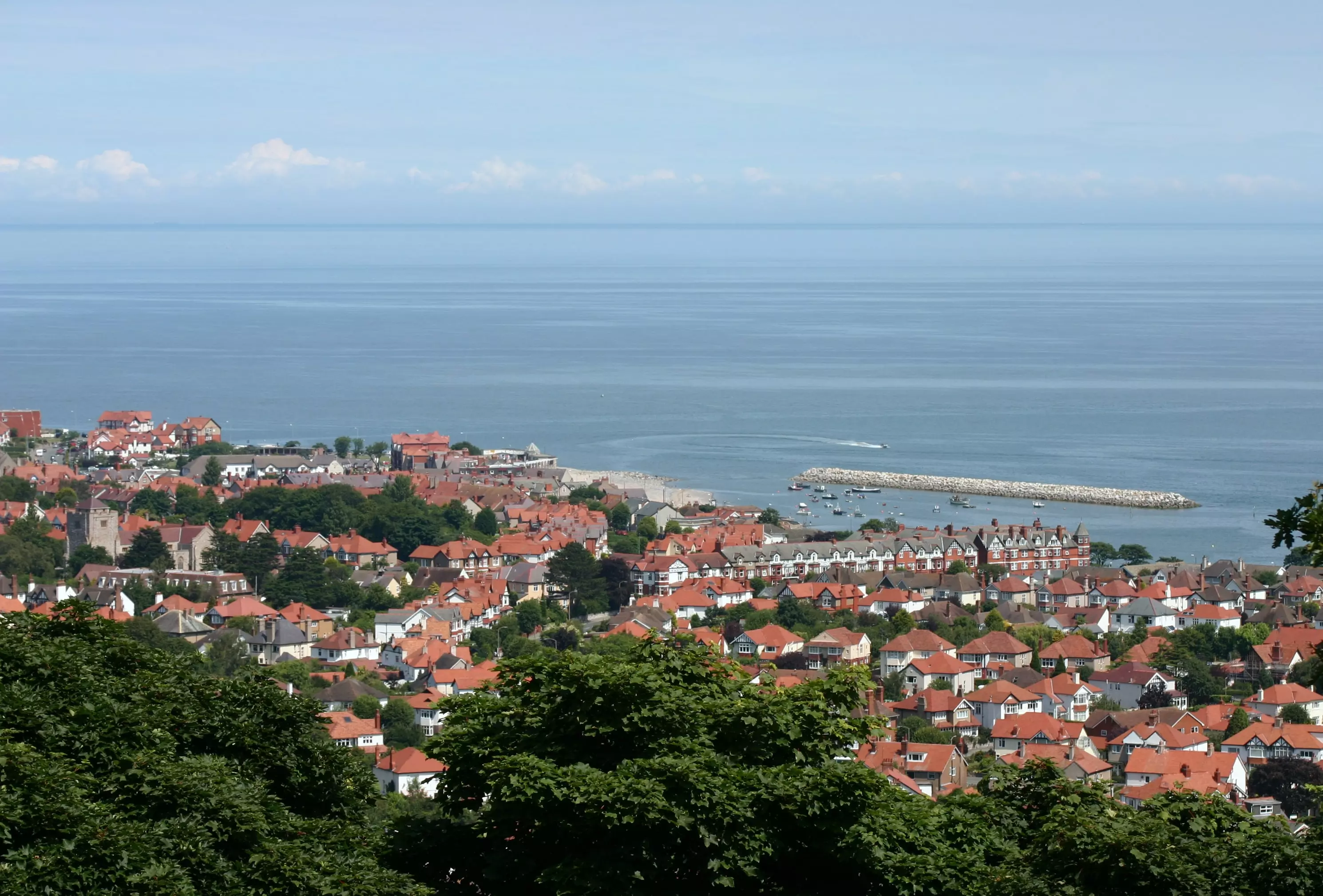 Wide-angle photo of Colwyn Bay, Wales, showing the local buildings by the sea, taken in bright sunshine.